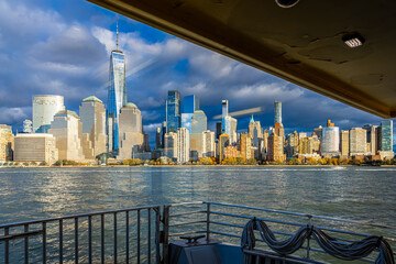 Lower Manhattan skyline from ferry on Hudson River under dramatic clouds