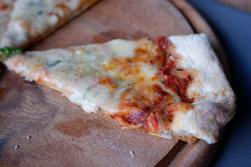 Appetizing slice of delicious cheesy pizza on rustic wooden board. freshly baked, savory meal with...