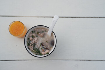 Warm bowl of rice porridge for healthy breakfast meal. comforting food, traditional soup with pork...