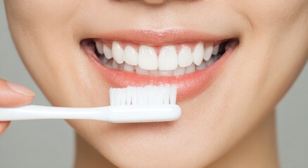 Close up of smiling mouth brushing white teeth with a toothbrush.