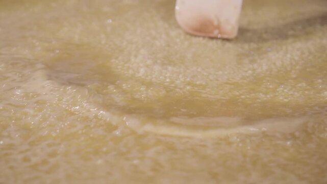 グツグツと沸騰する鍋　スープで米を煮る　かき混ぜる　料理・調理・パエリア