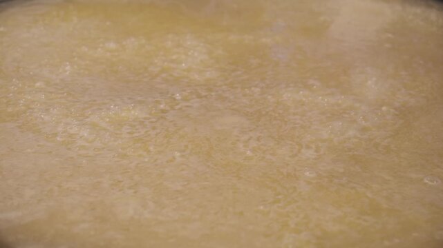 グツグツと沸騰する鍋　スープで米を煮る　かき混ぜる　料理・調理・パエリア