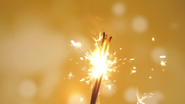 Holiday Christmas New Year or birthday joy sparkler on a yellow background