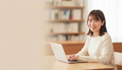 本棚のある部屋でノートパソコンに向かう笑顔の女性