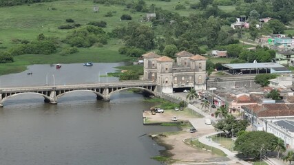 7x zoom aerial tracking shot over the historic Maua International Bridge. View starts at Jaguarao, Brazil side, showing the international border. Professional 4K master.