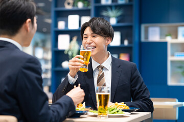 飲食店でビールを飲む若いビジネスマン