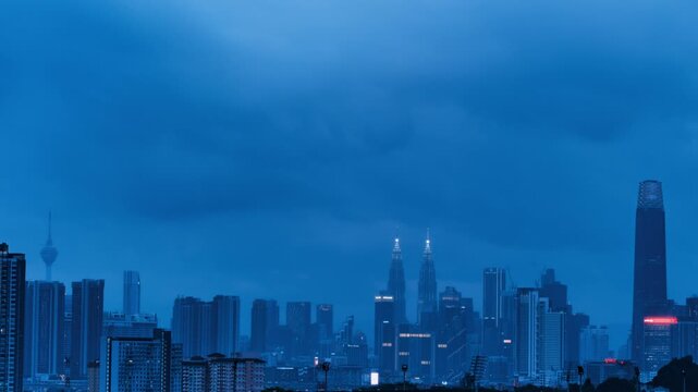 Time-lapse of the Kuala Lumpur skyline as heavy storm clouds roll in and lights flicker on at sunset