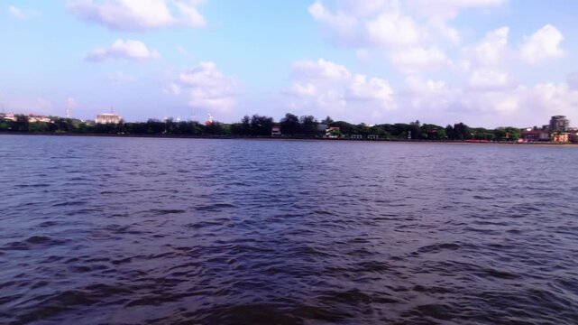 Mandovi River waves with trees and cloudy sky at panaji, goa, india. day time, semi circle shot, drone shot, 4k.