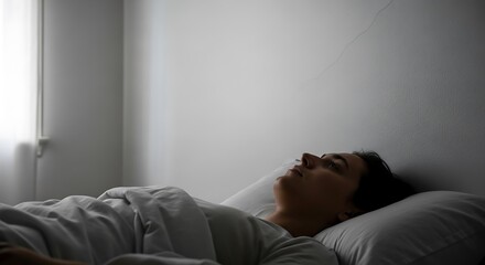 Woman sleeping peacefully in bed indoors.