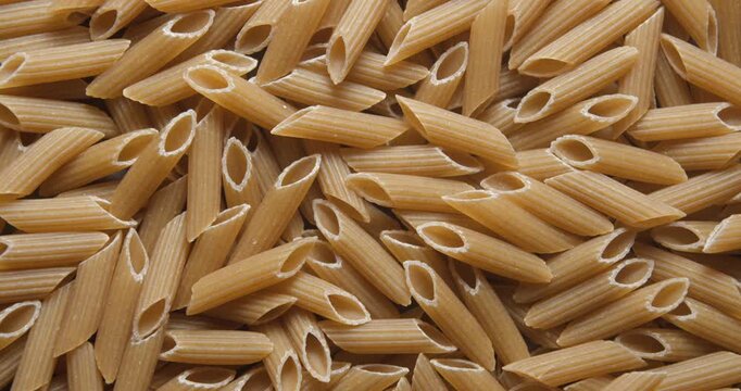 Penne pastas whole-grain close up studio shot over rotating
