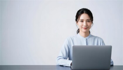 明るい部屋でパソコンを使い微笑む若い女性