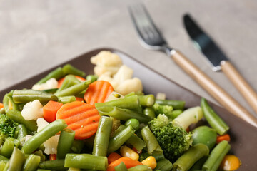 Plate with stewed mixed vegetables on grey background