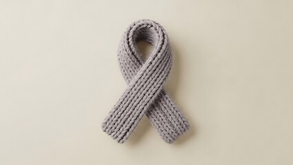 A soft, thick, grey knitted ribbon tied into a loop, representing awareness or a cause.