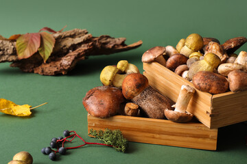 Wooden boxes with fresh mushrooms on green background, closeup