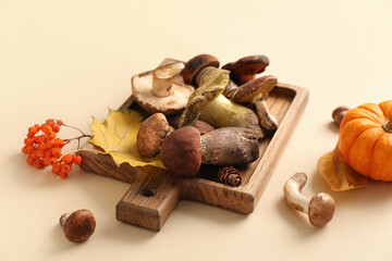 Composition with cutting board with fresh mushrooms on beige background, closeup