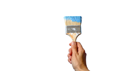 Hand holds a paint brush with blue paint on a black background