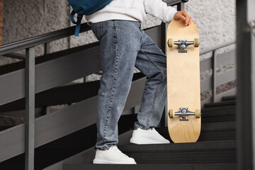 Young man with skateboard outdoors, closeup © Pixel-Shot