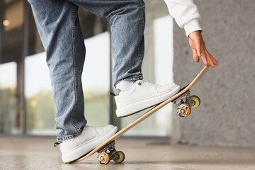 Legs of young man with skateboard outdoors, closeup © Pixel-Shot