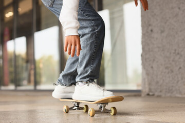 Legs of young man with skateboard outdoors, closeup © Pixel-Shot