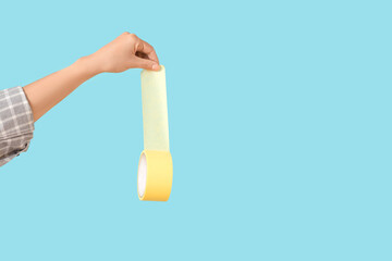 Female hand with adhesive tape on blue background