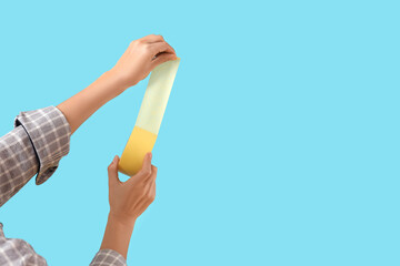 Female hands with adhesive tape on blue background