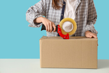 Young woman with adhesive tape on blue background, closeup