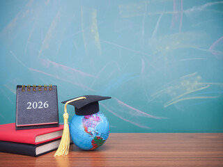 Student creative desktop , earth globe with graduation hat and 2026 desk calendar on hardcover book. Copy space for text, Back to school, Education concept