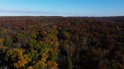 Van Buren road out of Nashville Indiana to Brown County forest canopy and distant horizon during autumn season, aerial flyover