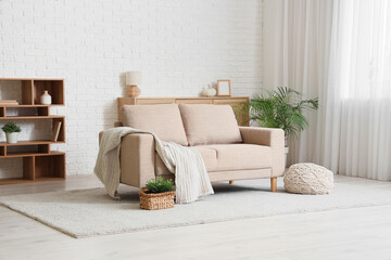 Interior of living room with light curtain, sofa and shelf unit