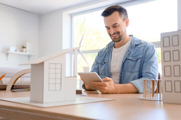 Fototapeta premium Male architect working with tablet computer at table in office