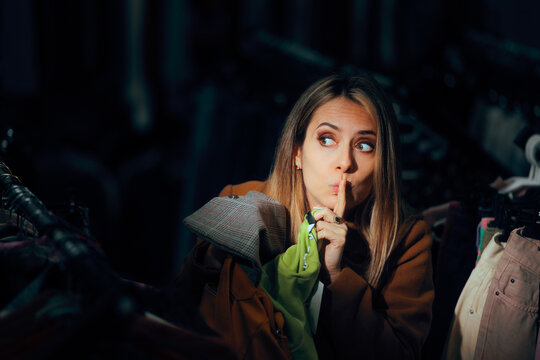 Funny Woman Trying to Steal Something in a Fashion Store. Mystery shopper with finger on lips testing textile quality 
