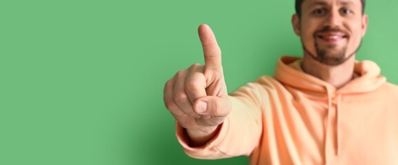 Young man using virtual screen on green background, closeup. Banner for design