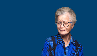 Elderly Asian woman smiling portrait with blue copy space.