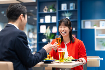 飲食店でビールを飲む男女