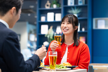 飲食店でビールを飲む男女
