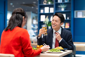 女性とビールを飲むミドルのビジネスマン
