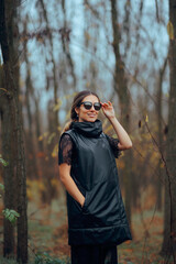 Woman Wearing a Thick Vest and Modern Sunglasses. Cheerful lady rocking trendy clothing during autumn seas