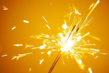 sparkler on a yellow background close-up. tinted