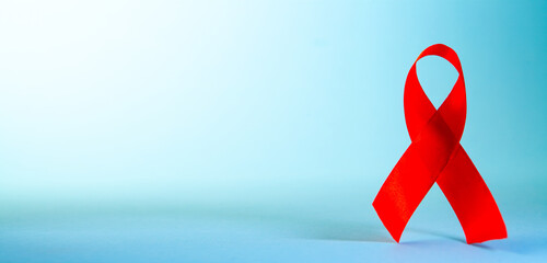 Red ribbon on blue background with copy space. World Aids Day concept.