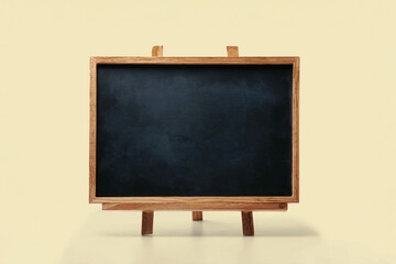 Empty chalkboard wooden easel on light background. Blank minimal blackboard with copy space for text, menu, education, business presentation concept.