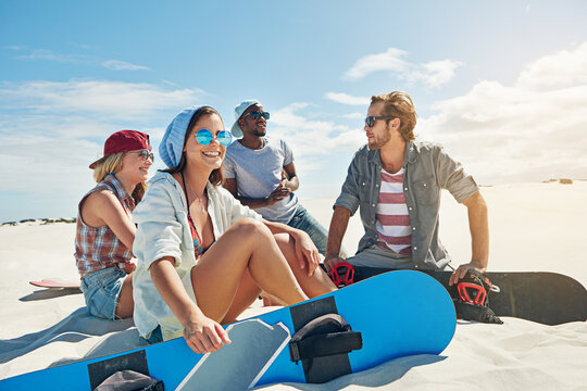 Hobby, relax and sand board with friends outdoor on dunes for adventure activity or extreme sports. Break, travel and vacation with group of sandboarding people in nature for bonding, holiday or trip