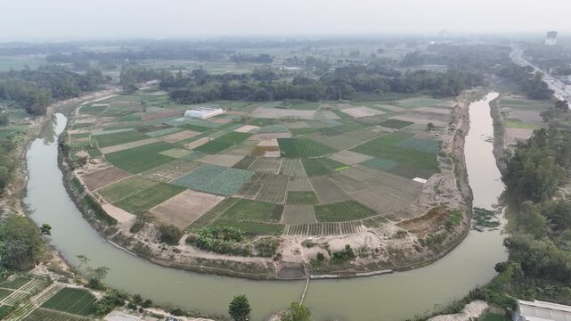 Scenic Aerial View of River Bend in Lush Green crop fied.