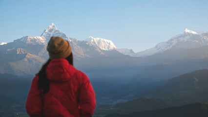 Blurred rear view of a woman traveler looking at Machapuchare peak, Annapurna mountain range in Pokhara , Nepal