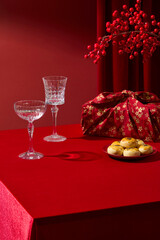 Red background and festive Chinese New Year elements such as winterberry, cakes, wrapped gifts and glass cups. Ideal for posters or vertical banner designs. Vertical frame, space for add text