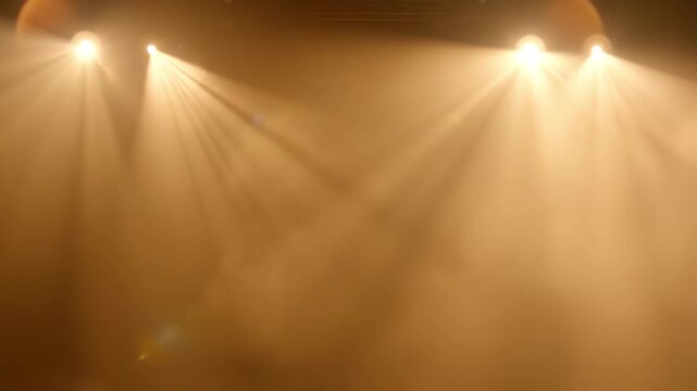 Warm stage light beam haze theater golden spotlight dramatic fog atmosphere theatrical spotlight beams cross over smoky concert stage creating visible light rays and amber glow
