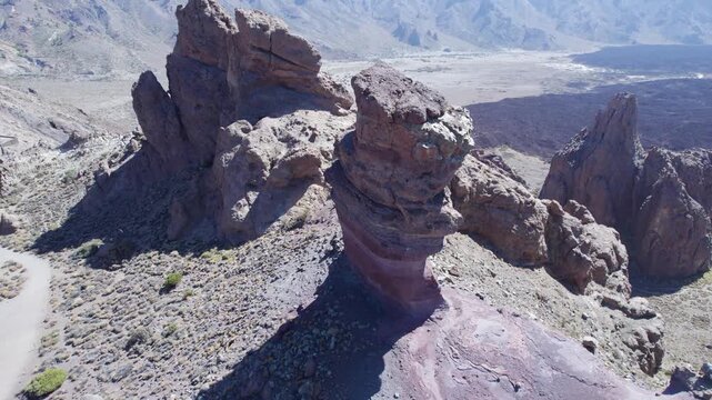 Aerial drone footage flying backward to reveal the iconic Roques de Garc&iacute;a rock formations within Teide National Park in Tenerife, Spain, widely used for travel and destination establishing shots.