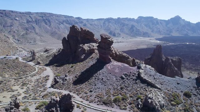 Drone flying forward toward the Roques de Garc&iacute;a rock formations in Teide National Park, Tenerife, Spain, showing a wide volcanic landscape used for travel and destination establishing shots.