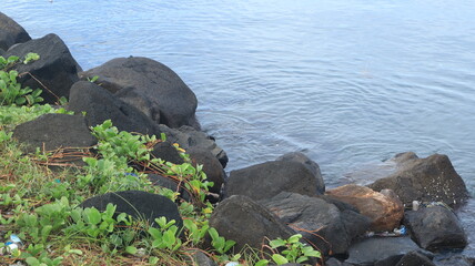 Rocks are arranged on the edge of the beach, the sea water is calm