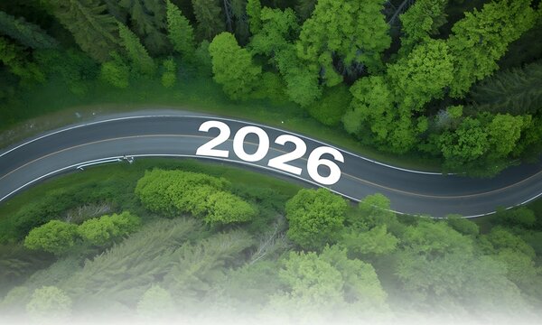 Aerial view of a winding road in a lush green forest with the year 2026 curved mountain - Powered by Adobe