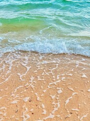 Blue and white waves on a brown beach.